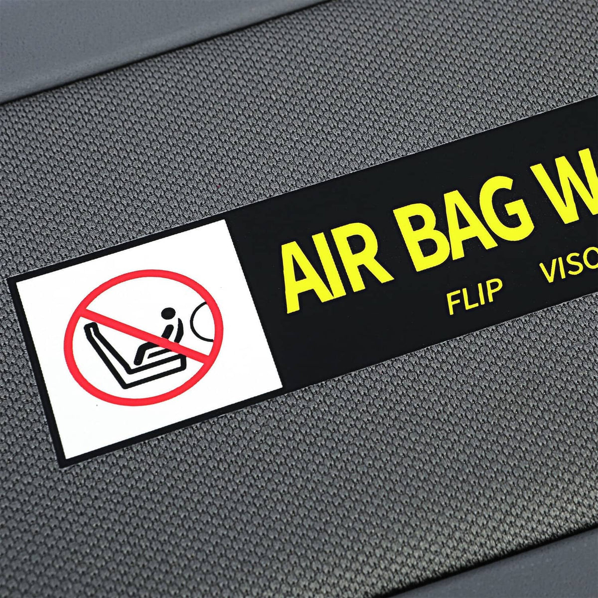 Dark gray sun visor with AIR BAG WARNING sticker and no-movement icon