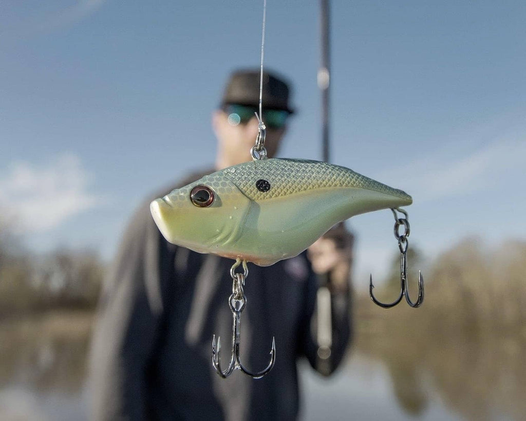 Green crankbait with dark spots and treble hooks, hanging from chains