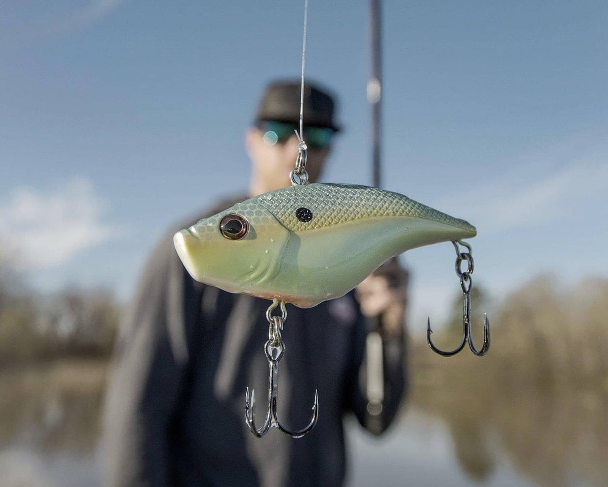 Green crankbait with dark spots and treble hooks, hanging from chains
