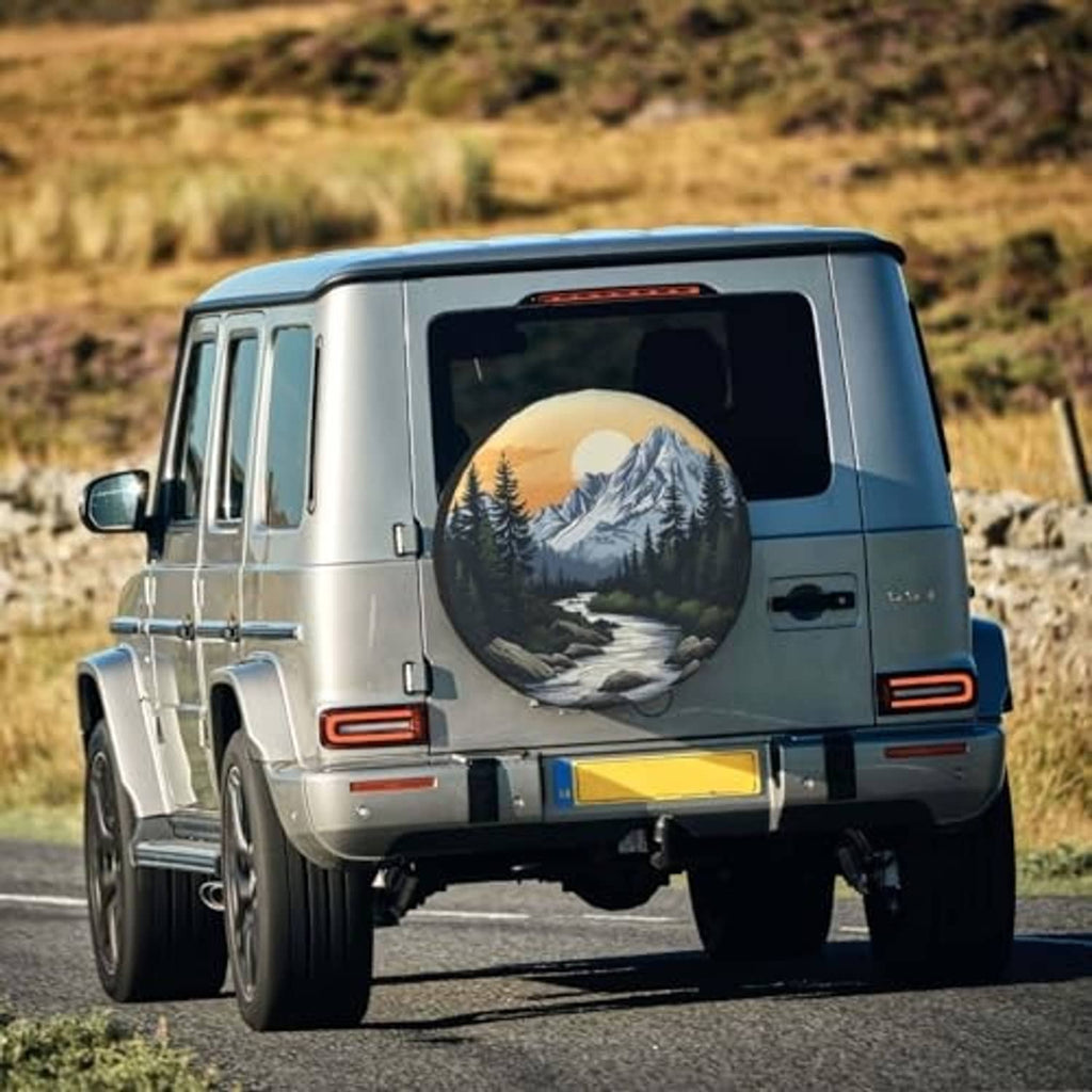 Mountain scenic spare tire cover on rear of blue SUV