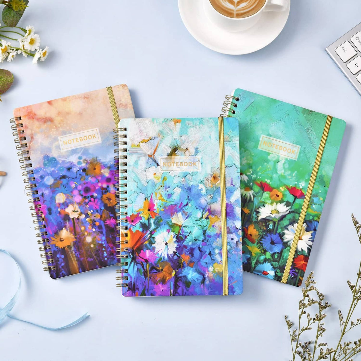 A5 spiral notebook 3-pack flat-lay view with watercolor floral covers and gold coil rings
