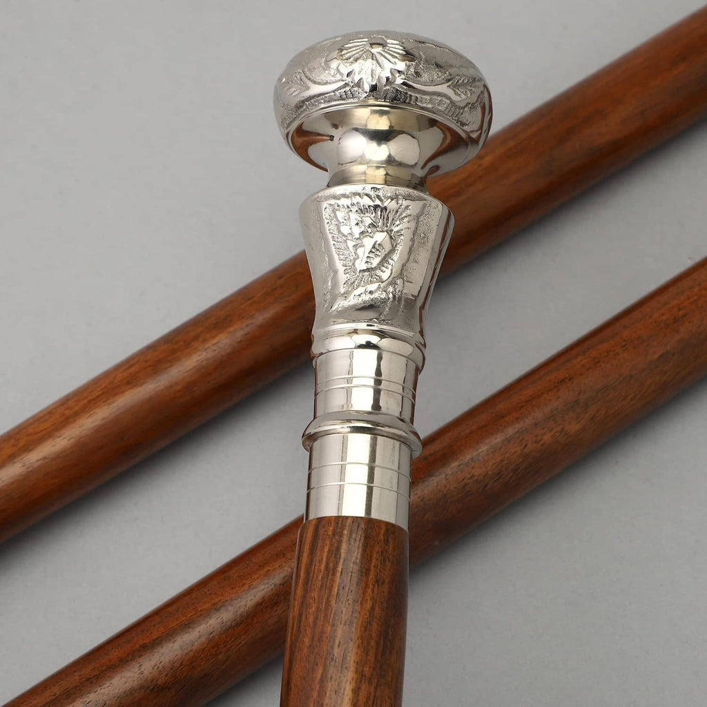 Close-up of brown wooden walking cane cross with silver decorative handle