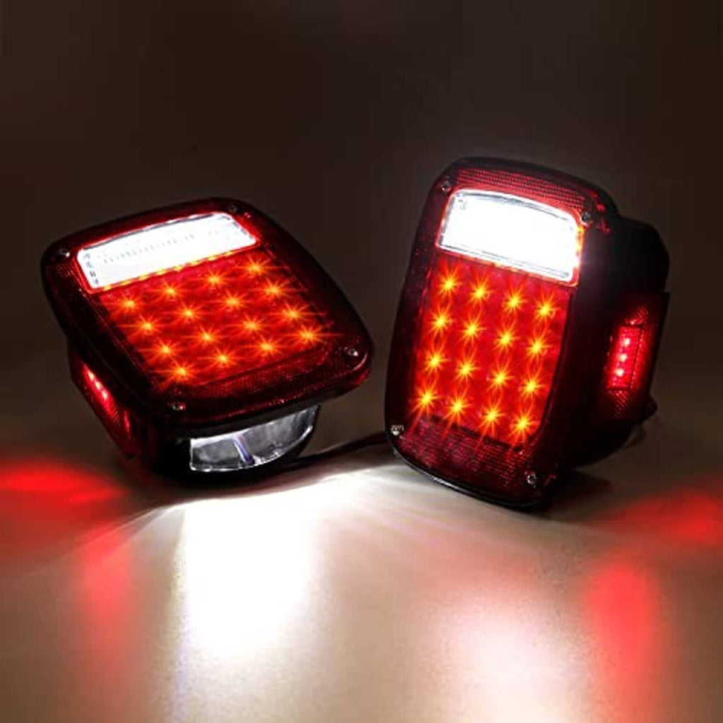 Pair of square tail lights glowing red with bright white reverse LED strips