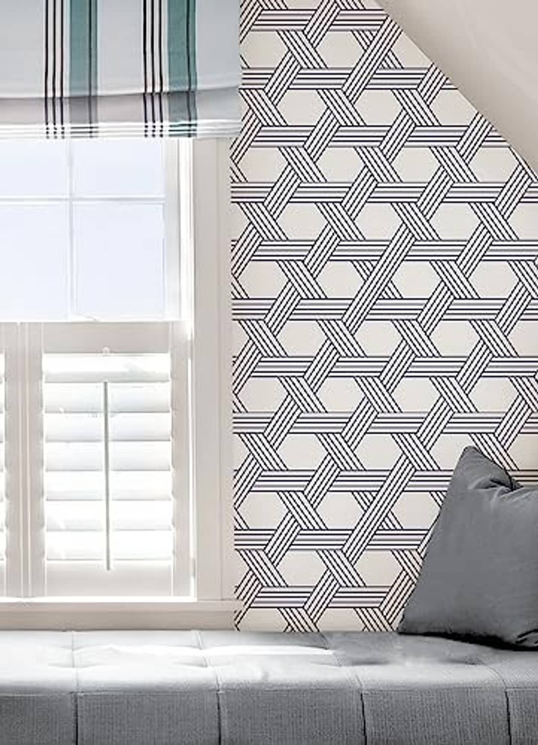 Blue-and-white geometric lattice wallpaper on a room corner wall.