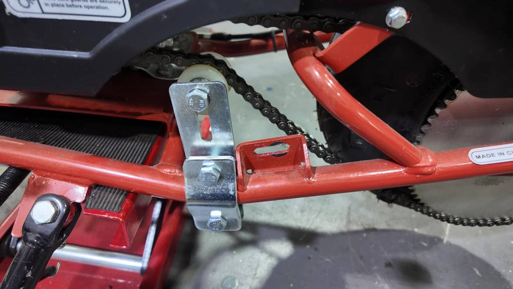Chain tensioner bracket mounted on engine frame beside chain, with guide wheel