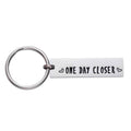 Stainless steel keychain with engraved 'ONE DAY CLOSER' quote and heart accents