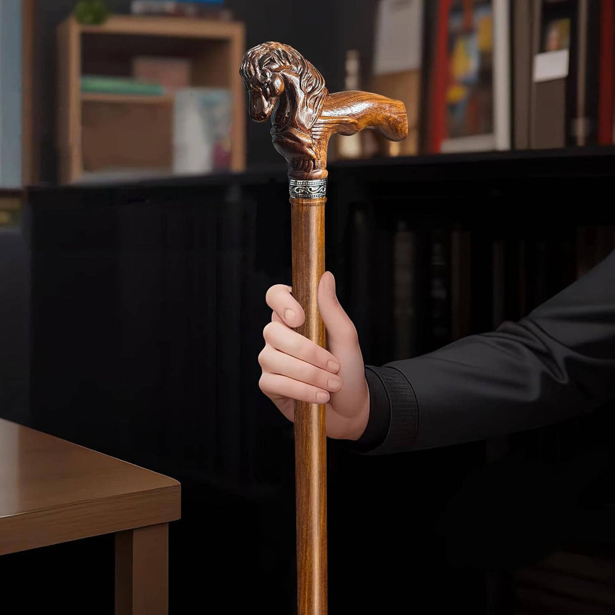 Wood walking cane with carved horse head handle, hand holding the cane upright