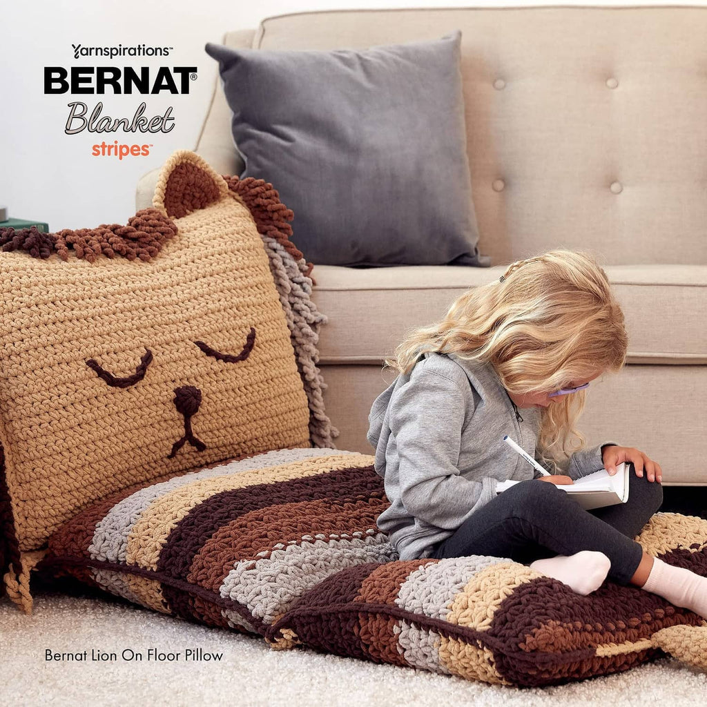 Multicolor crocheted blanket with tan, cream, and brown striped blocks