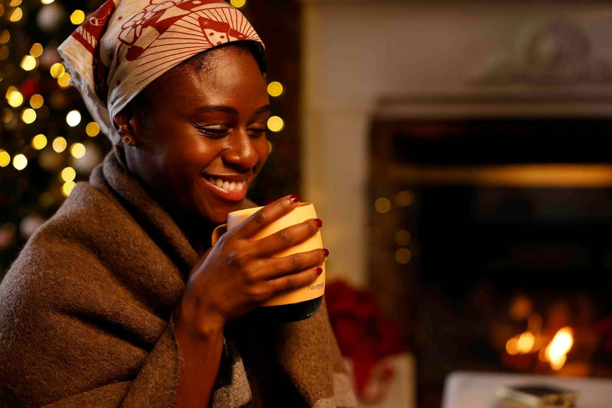 Self-heating coffee mug with lid as someone takes a sip