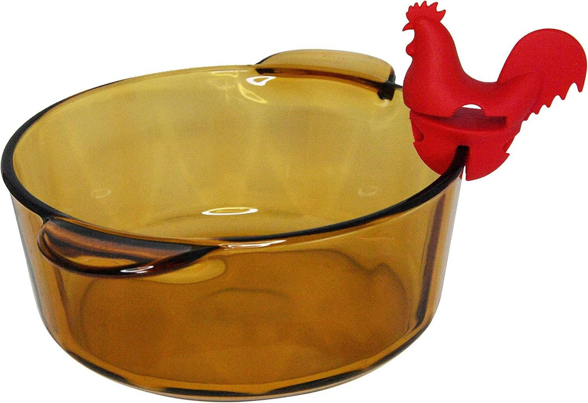 Red rooster spoon holder perched on amber pot rim