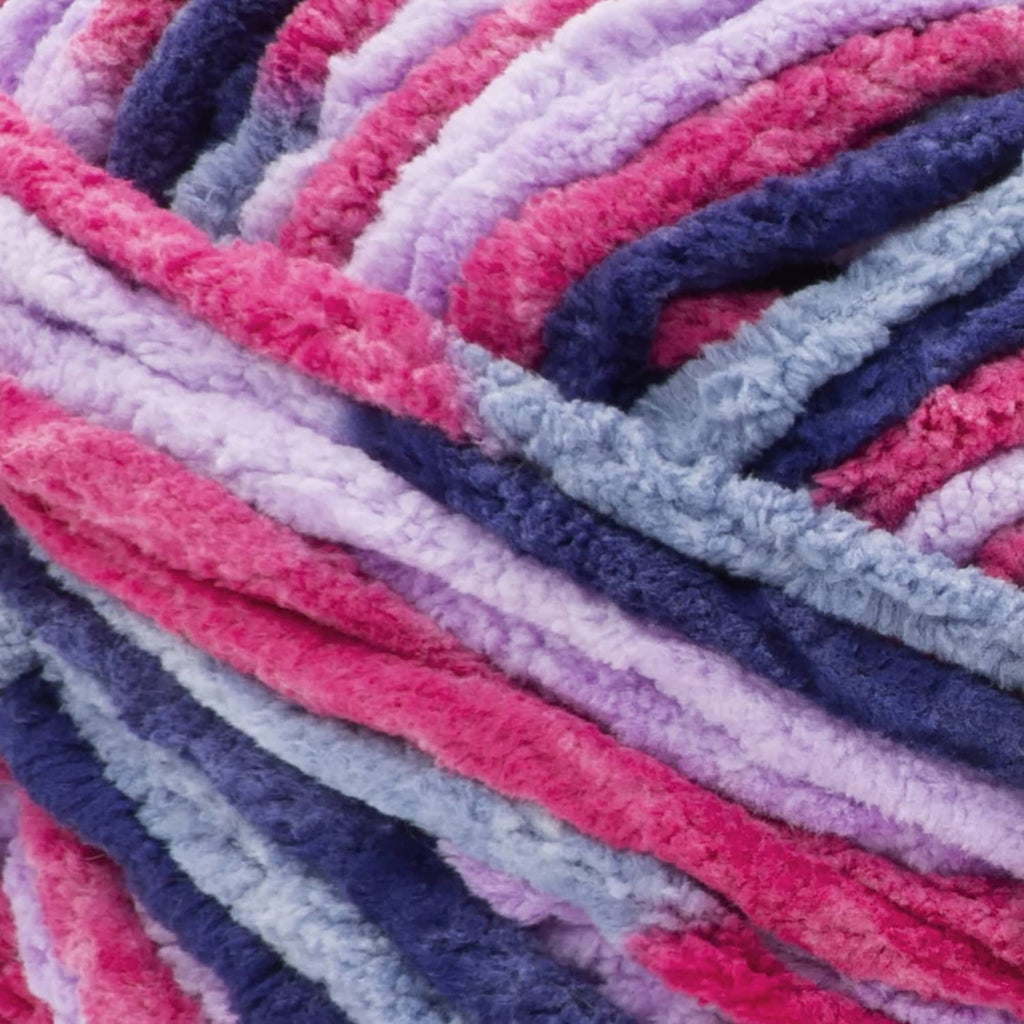 Close-up of super bulky chenille yarn stripes in pink, lavender, blue, and navy