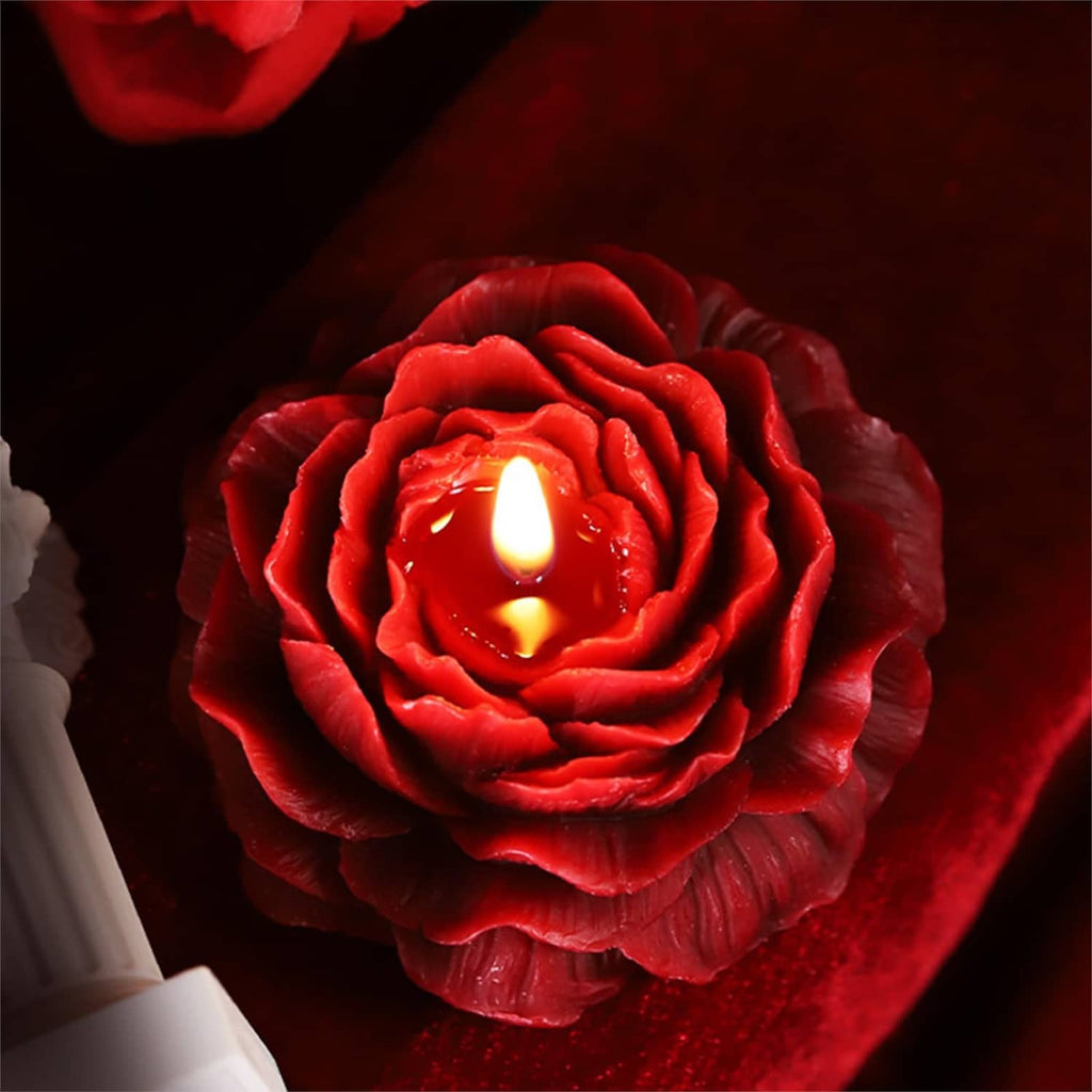 Red peony flower candle with two lit wicks in the center