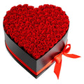 Heart-shaped black rose gift box with red preserved roses and orange-red ribbon bow
