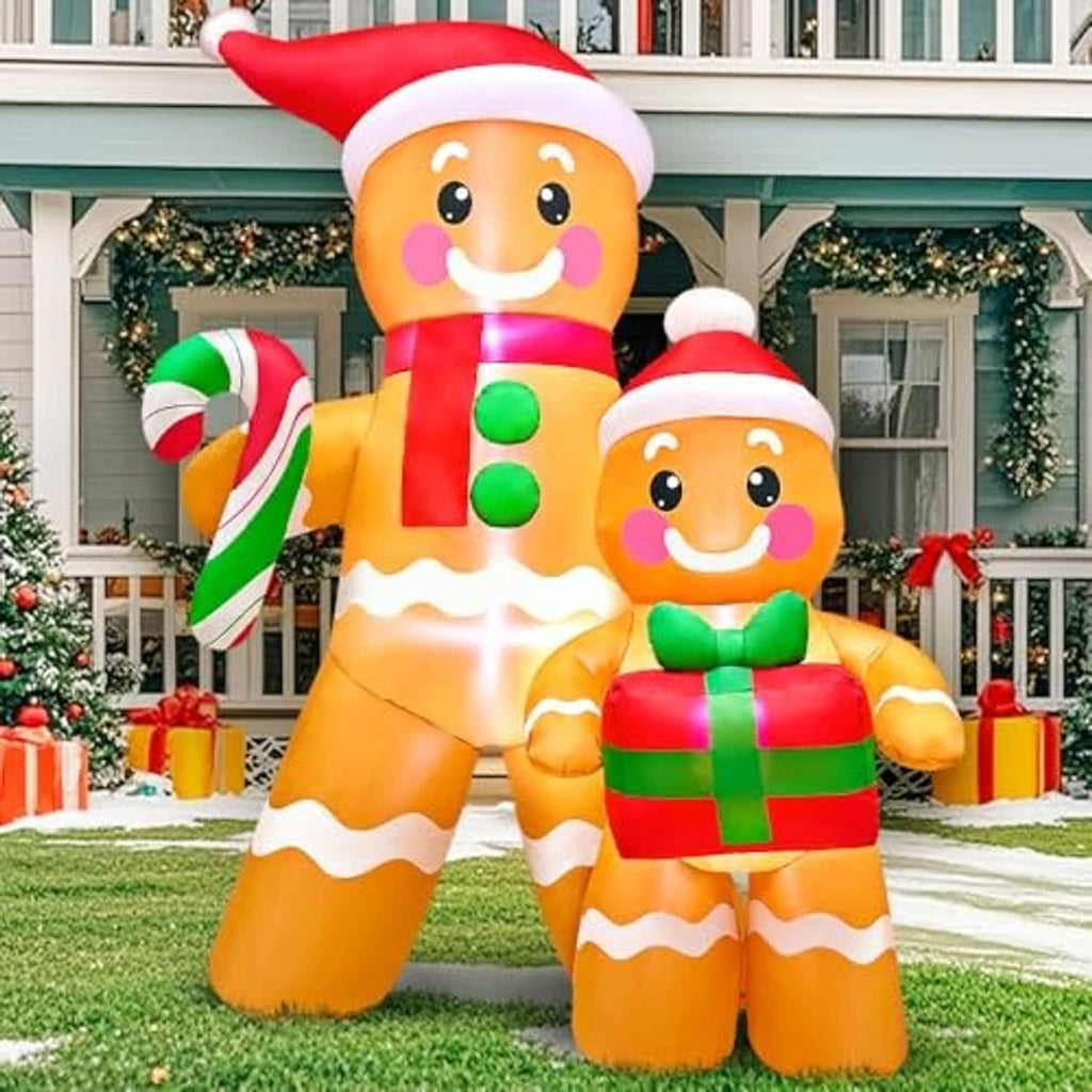 Inflatable gingerbread figures on a front lawn, red hats, candy cane and wrapped gift