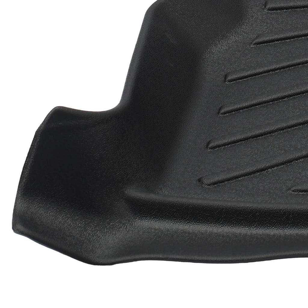 Black molded floor mat corner with textured grip ridges and raised outer edge.