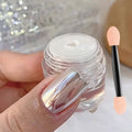 Chrome nail powder jar and nail swatch with glossy silver mirror effect on pink base