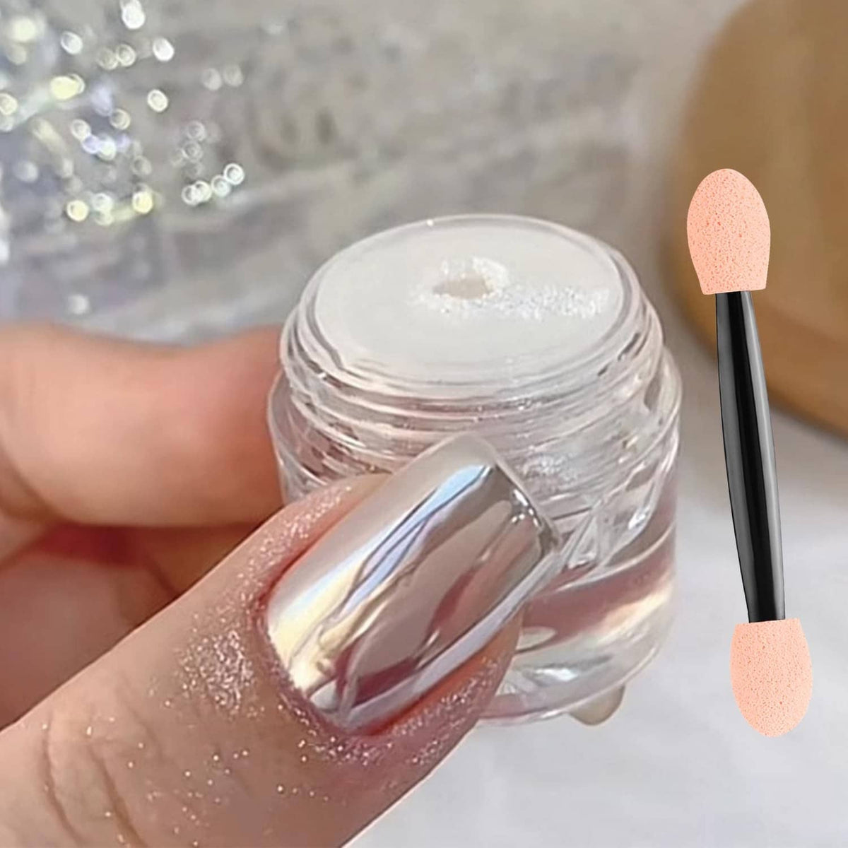 Chrome nail powder jar and nail swatch with glossy silver mirror effect on pink base