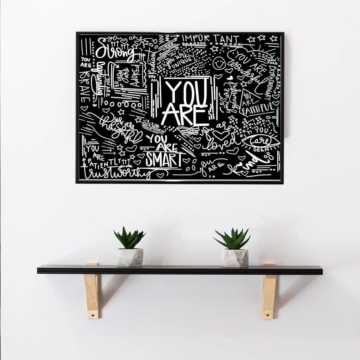 Rectangular black and white inspirational tapestry with “YOU ARE” typography pattern