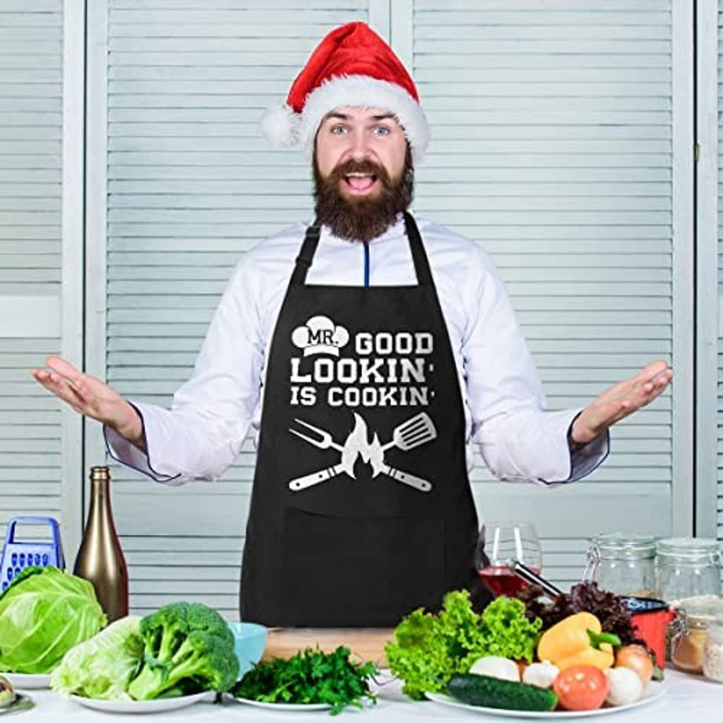Black cotton apron with 'MR. GOOD LOOKIN' IS COOKIN' graphic and dual pockets