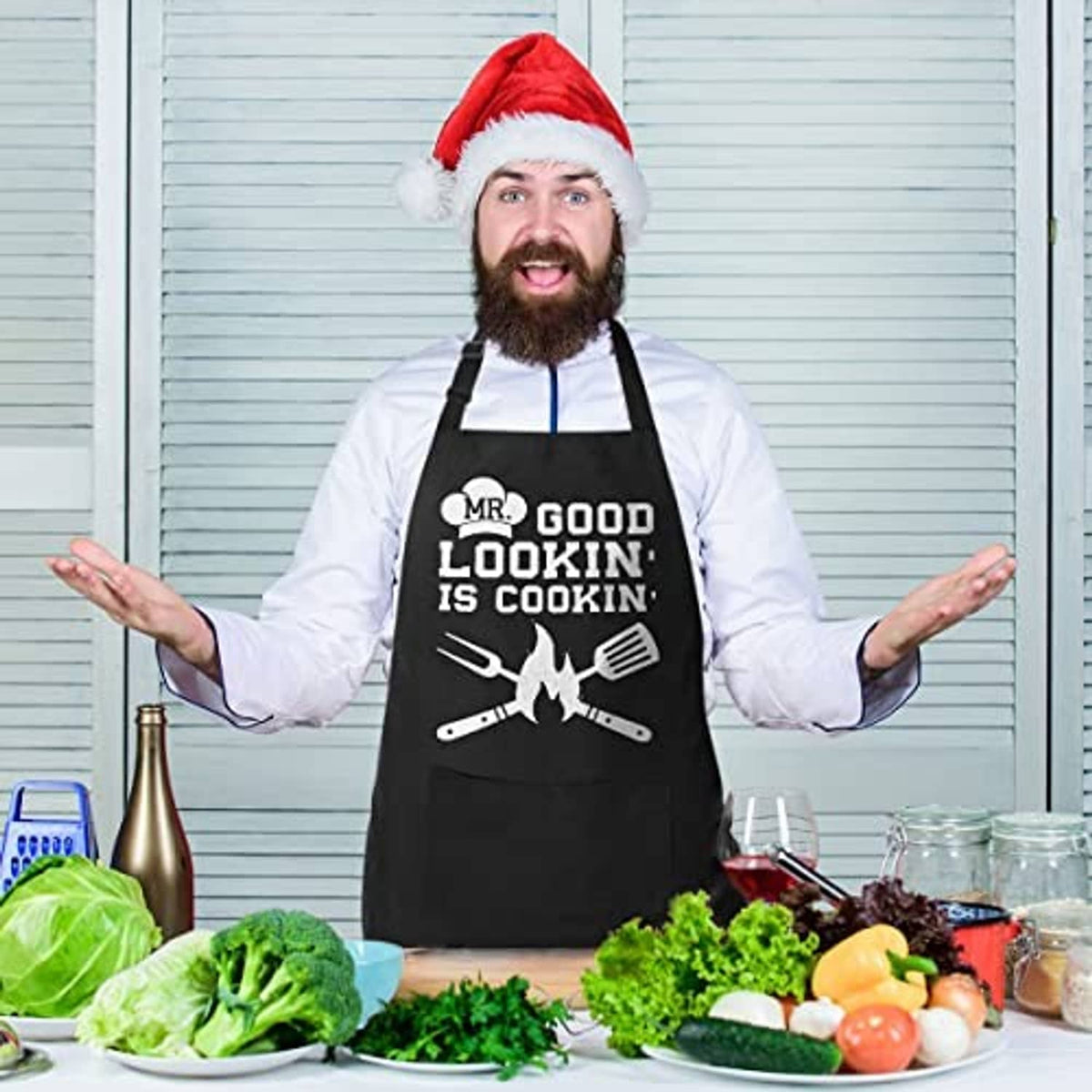 Black cotton apron with 'MR. GOOD LOOKIN' IS COOKIN' graphic and dual pockets