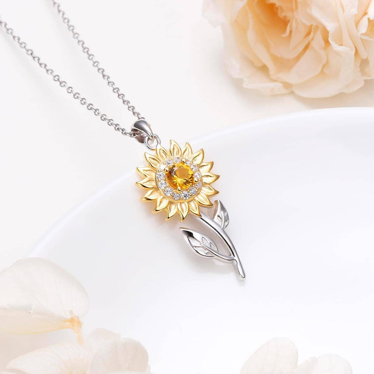 Sunflower pendant necklace with gold petals, amber crystal center, and silver leaves