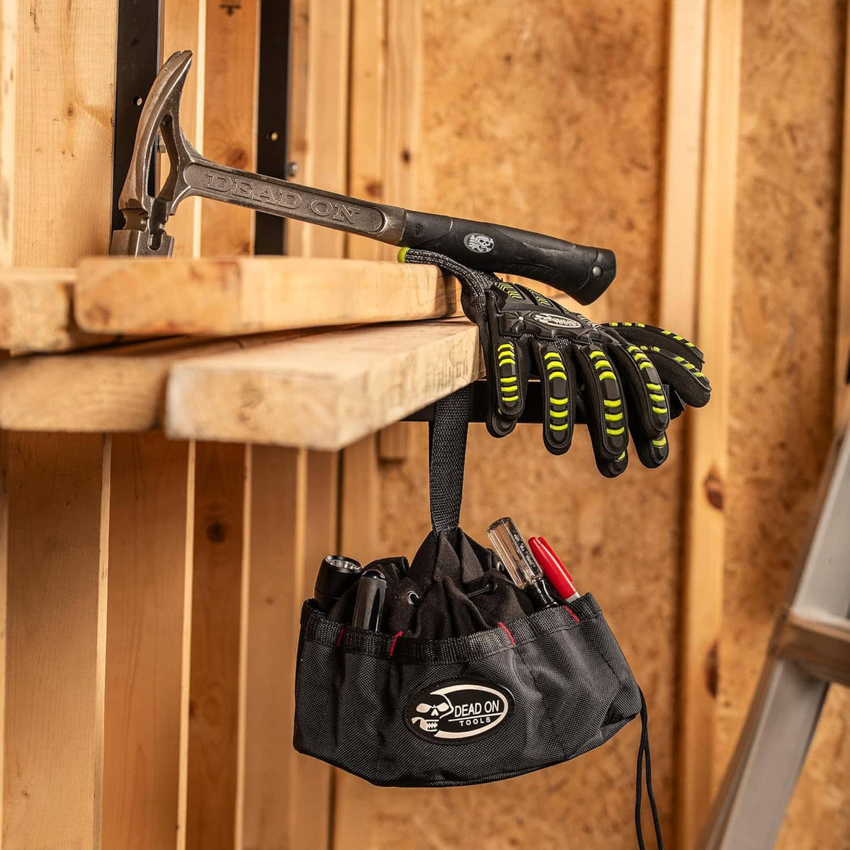 Black tools parachute bag with logo, holding gloves and hand tools, hanging by strap