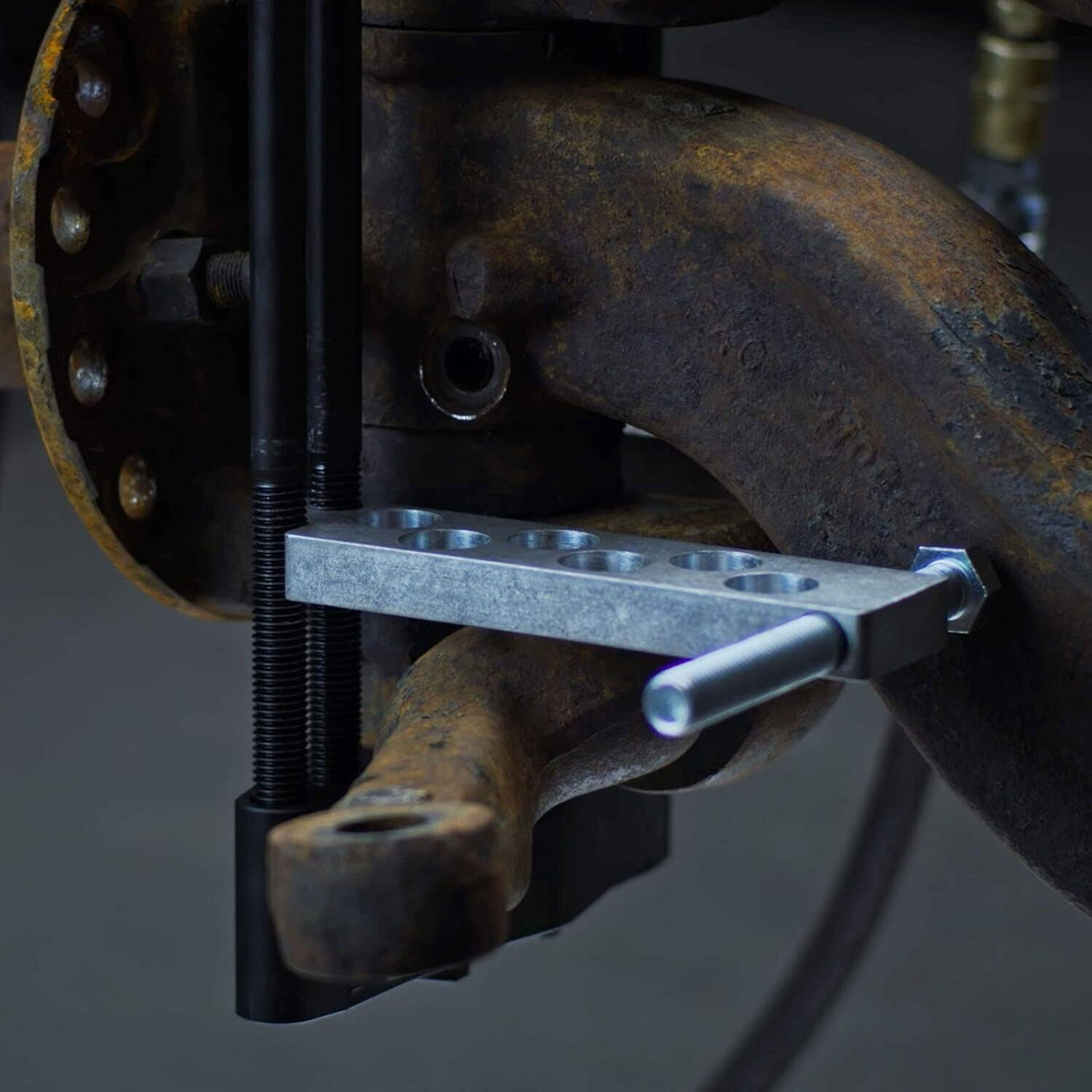 King pin press tool applying force to a vehicle axle joint with metal clamp