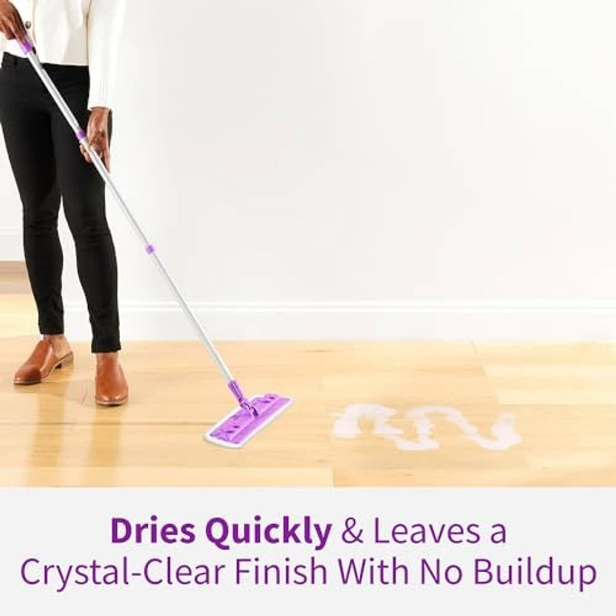 Extension mop with purple pad cleaning a light wood floor