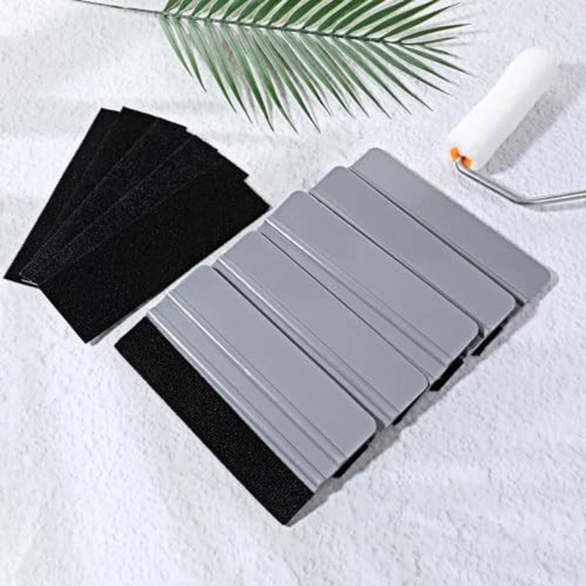Gray plastic squeegees with black felt pads, laid out with extra felt sheets.