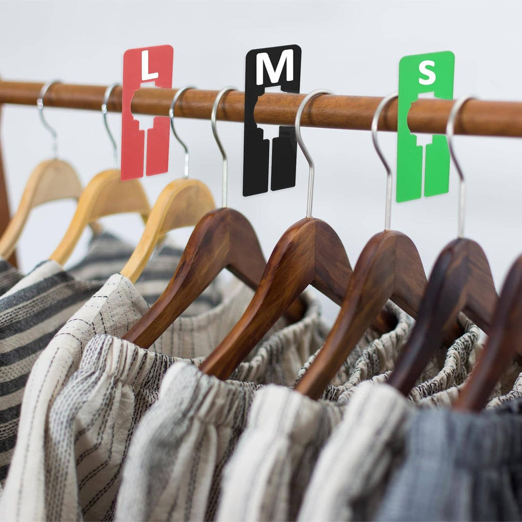 Color-coded hanging closet dividers clipped on a garment rack with cutout silhouettes