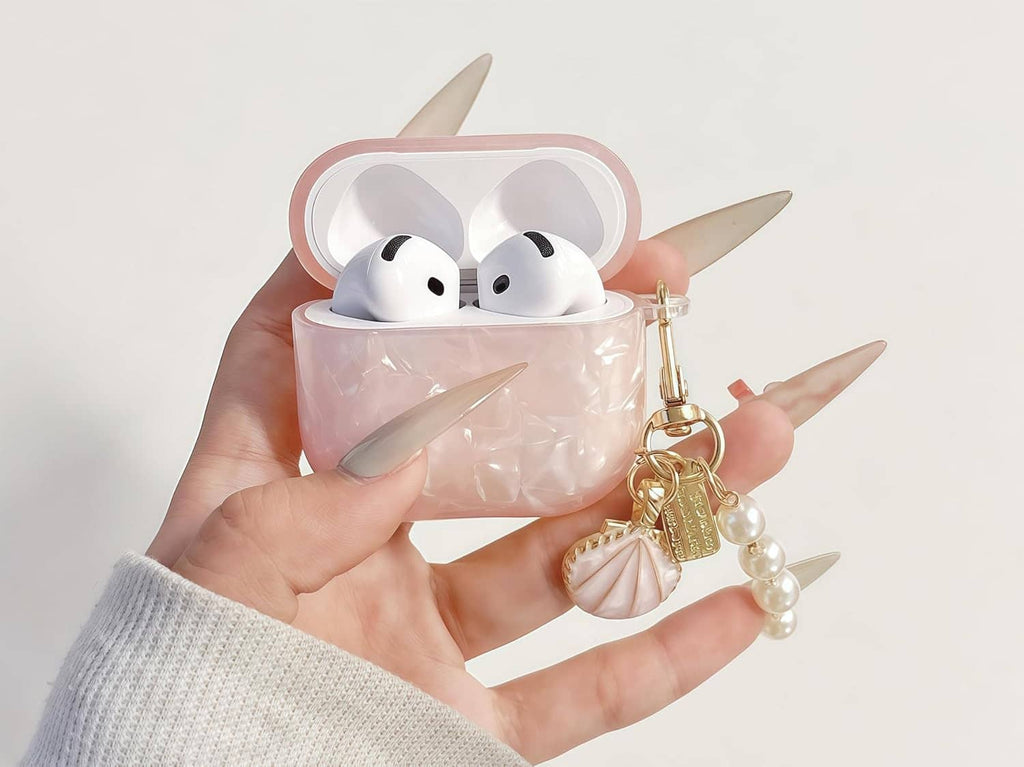Translucent pink earbuds case with glitter shell pattern and gold pearl charm, open view