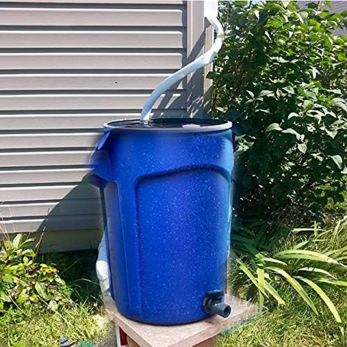 Blue rain barrel with attached PVC drain spigot near the base