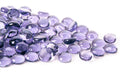 Purple mini glass gems, round and faceted, in a mixed pile for crafts or mancala