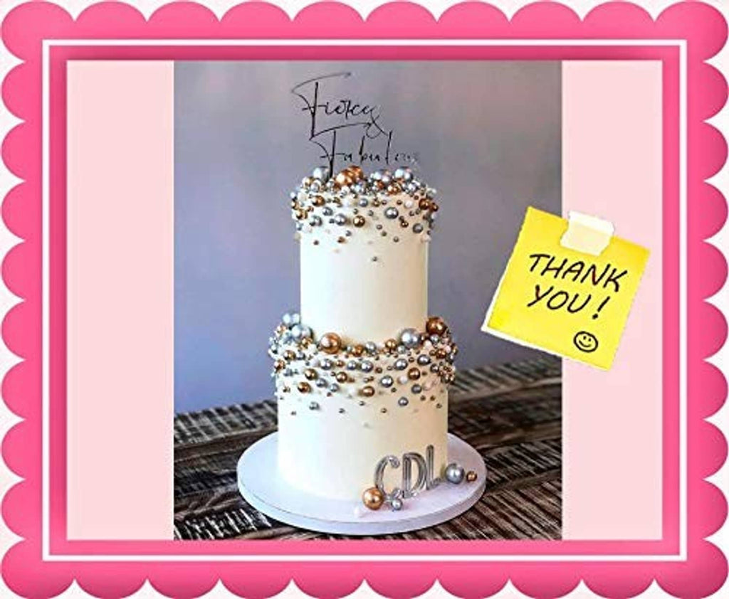 White celebration cake covered with gold glitter sprinkles and pearl dots
