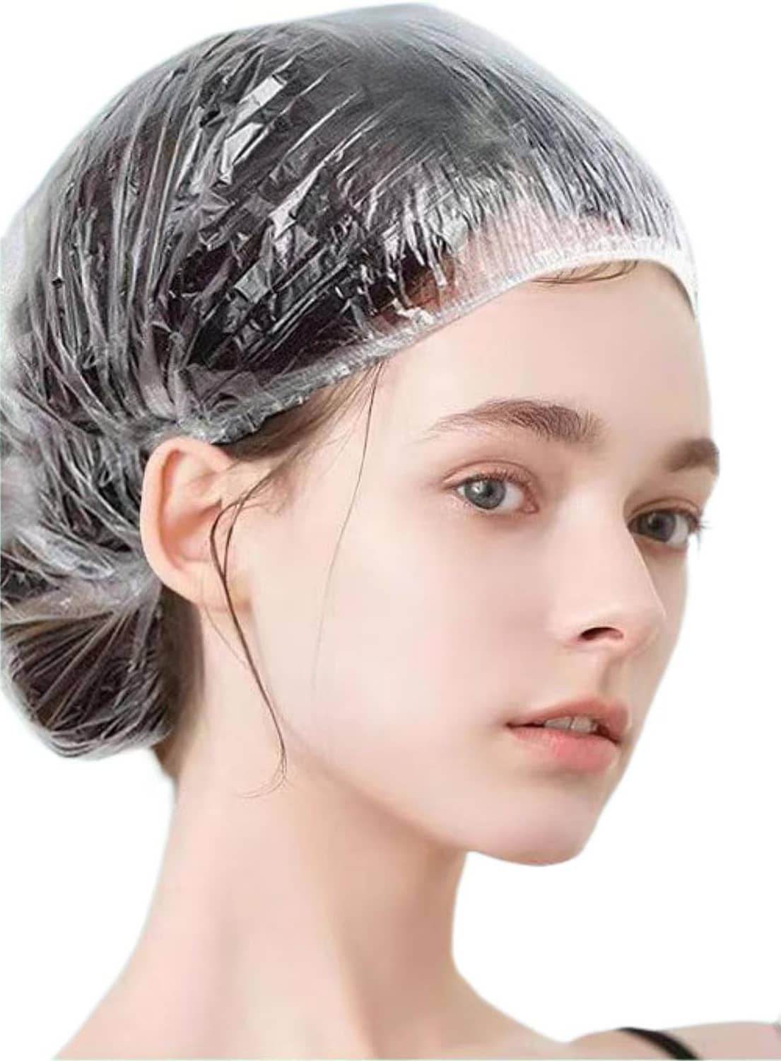 Gray-tinted disposable shower cap covering hair, snug around the hairline