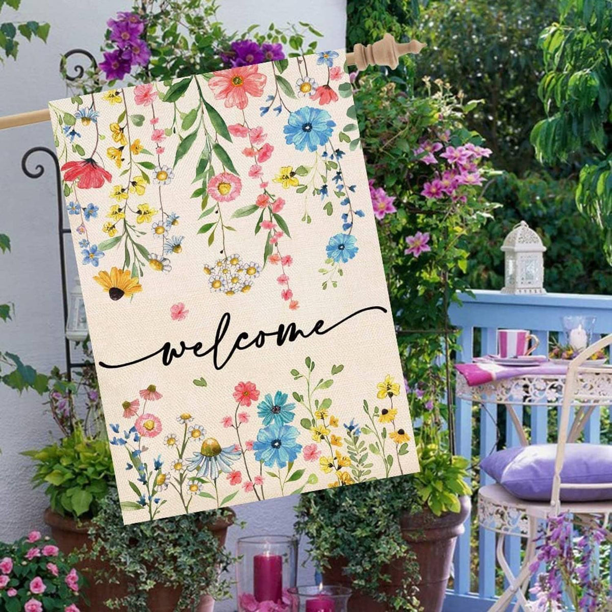 Floral welcome house flag hanging on a wooden pole, cream fabric with colorful flowers