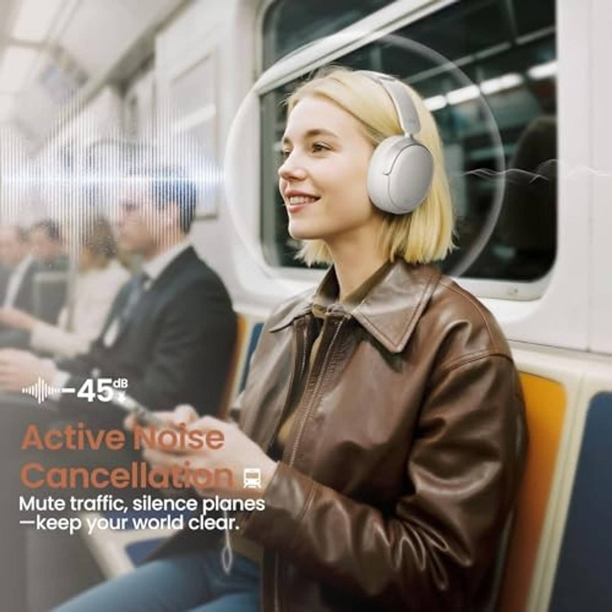 Light gray over-ear wireless headphones on a person, with cushioned ear pads.