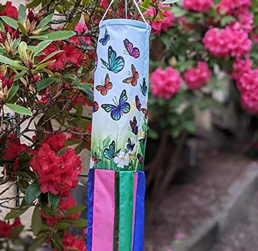 Butterfly windsock hanging among flowers, with colorful ribbon streamers