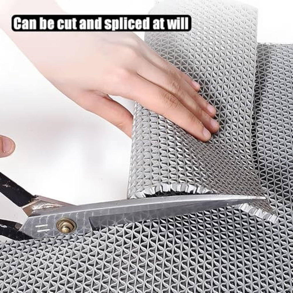 Gray non-slip mat being cut with a utility knife on textured surface
