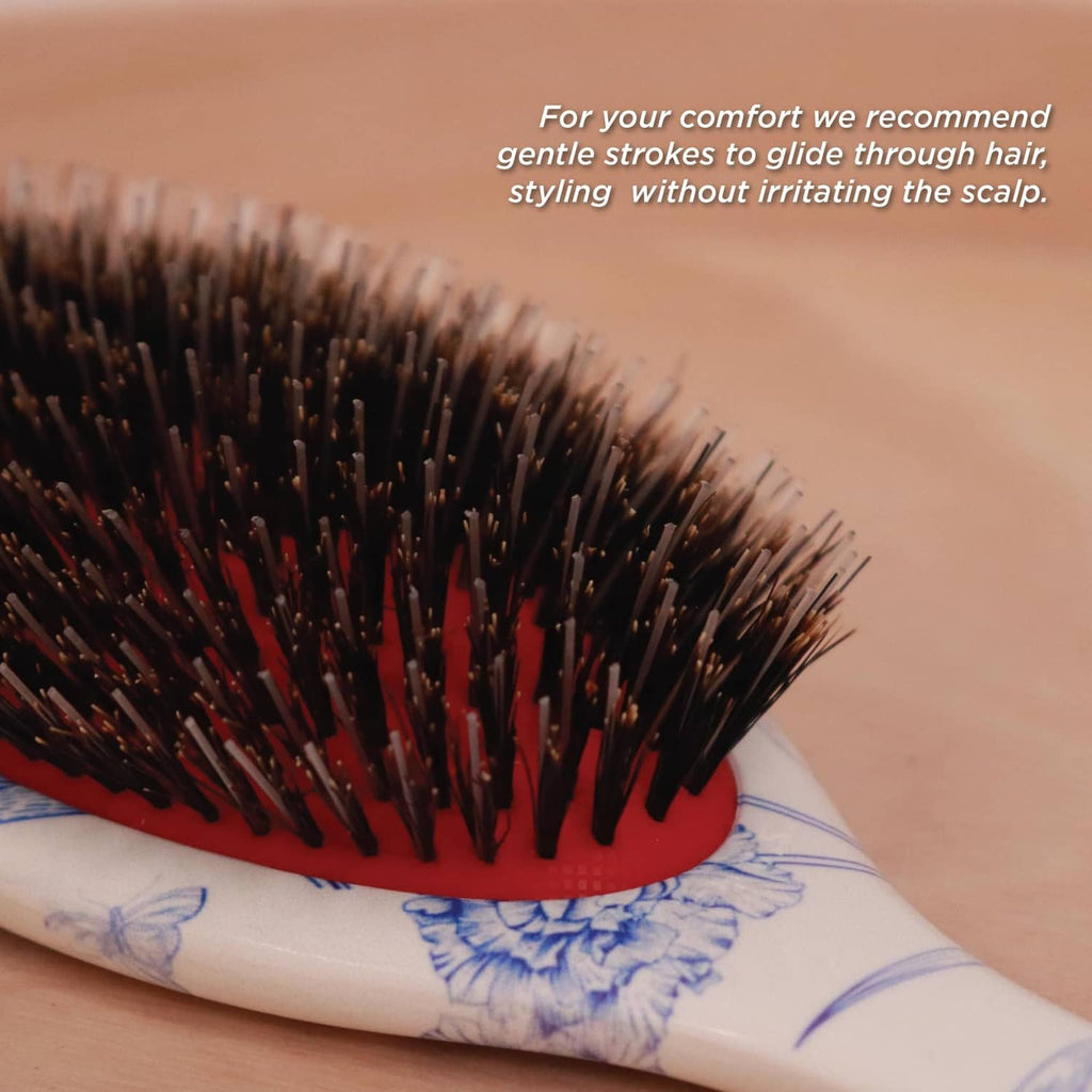 Close-up of boar bristle hair brush on hair, showing dense dark and red bristles