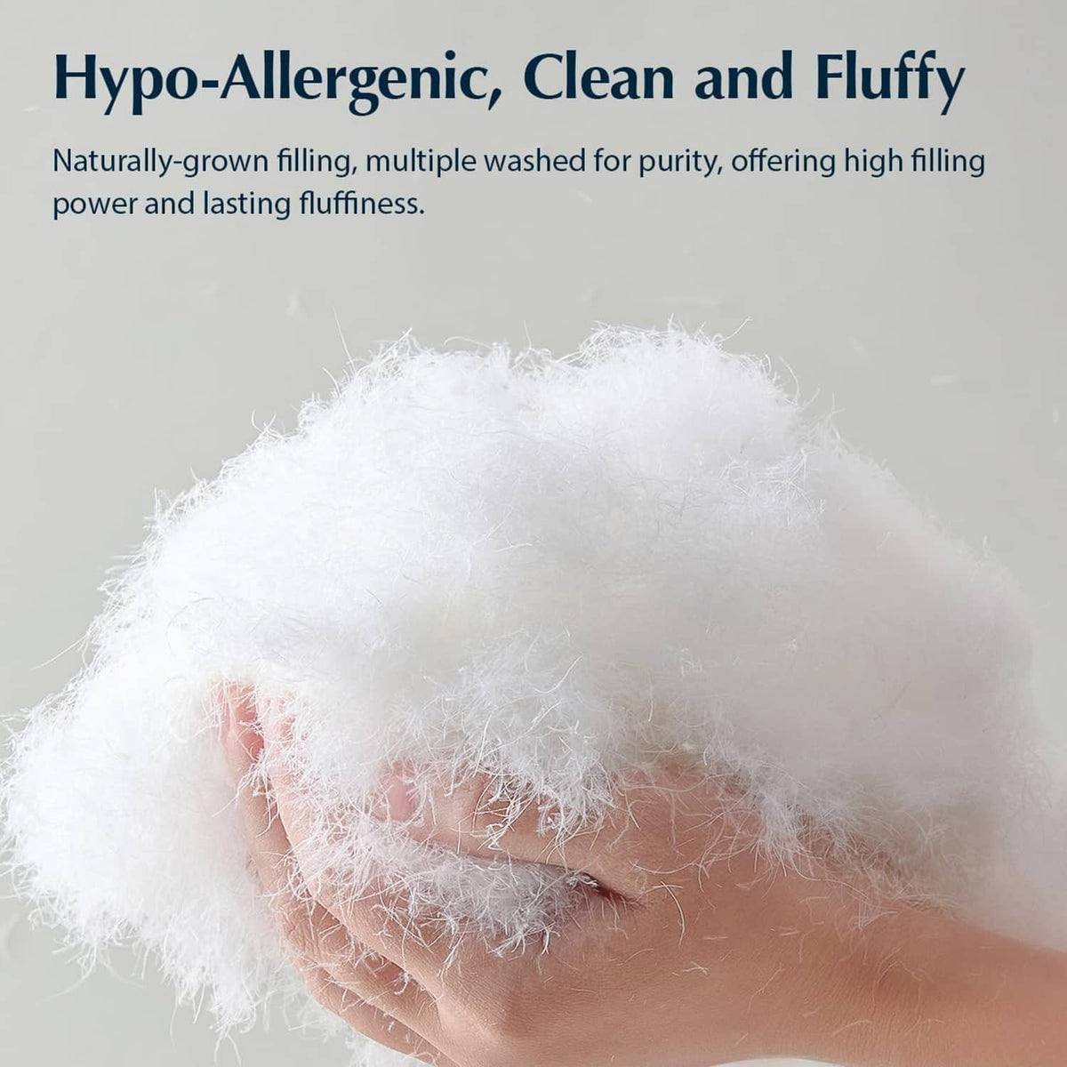 Fluffy white down filling for bed pillows, held in a hand