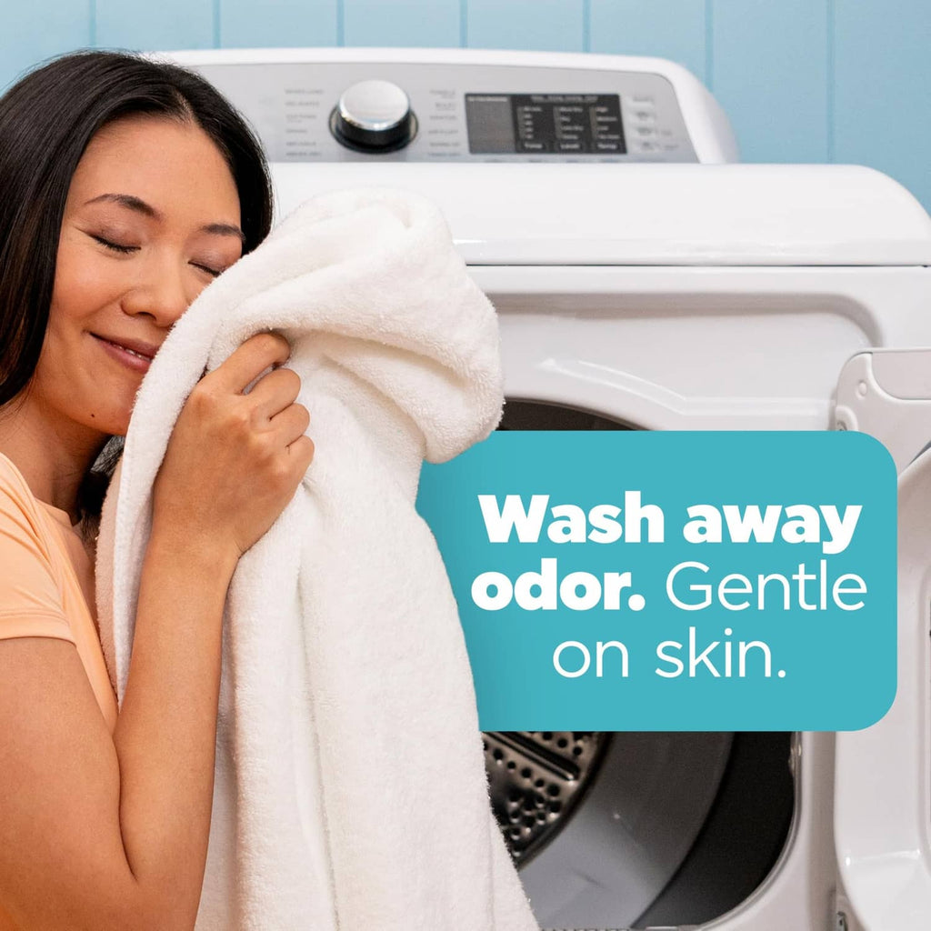 Woman drying with a white towel in front of a washing machine