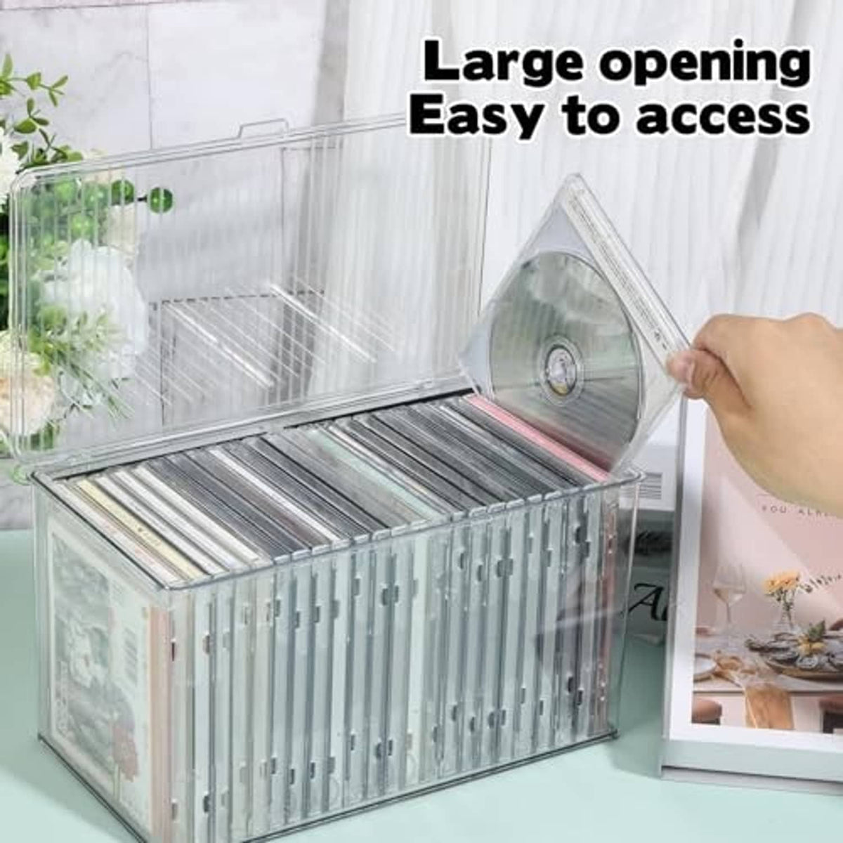 Clear CD organizer box with large opening, CD being accessed through lid