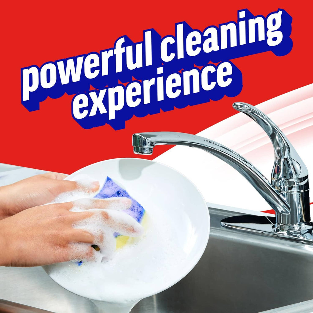 Hand holding a foamy plate near a sink faucet, dishwashing with detergent
