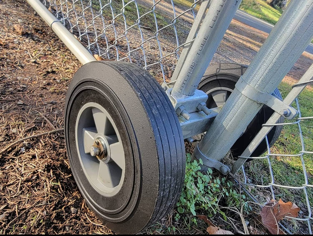 Solid rubber wheel on hand truck axle, textured black tire, gray metal spokes