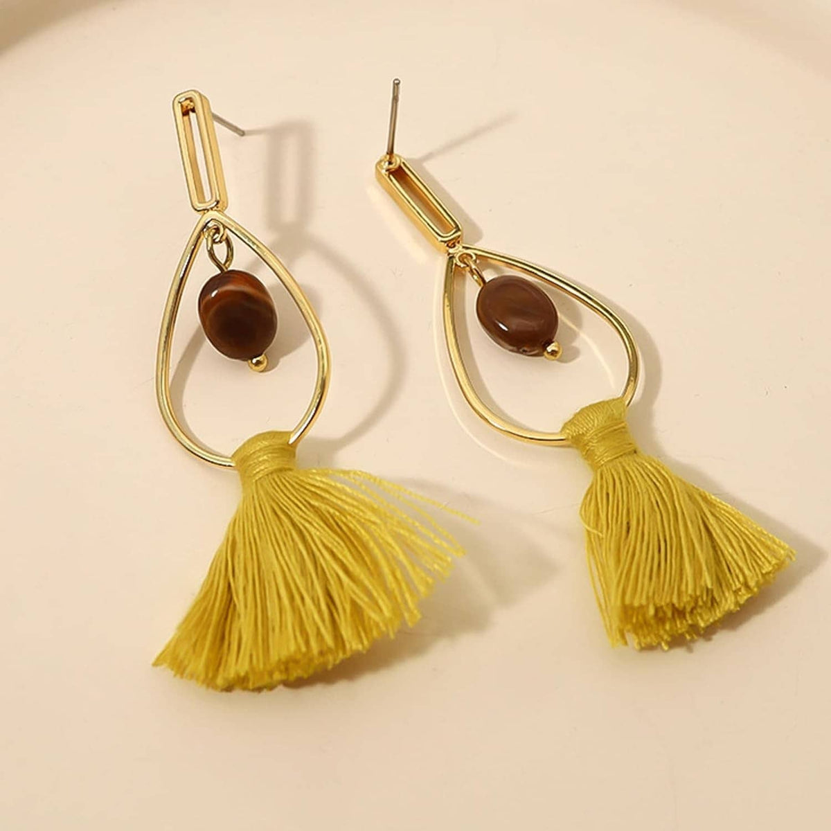 Gold-tone earrings with teardrop frames and yellow tassel dangles