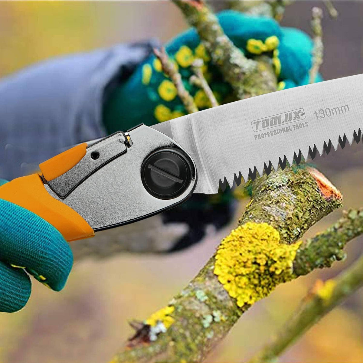 Pruning hand saw cutting a small branch with yellow handle and silver folding blade