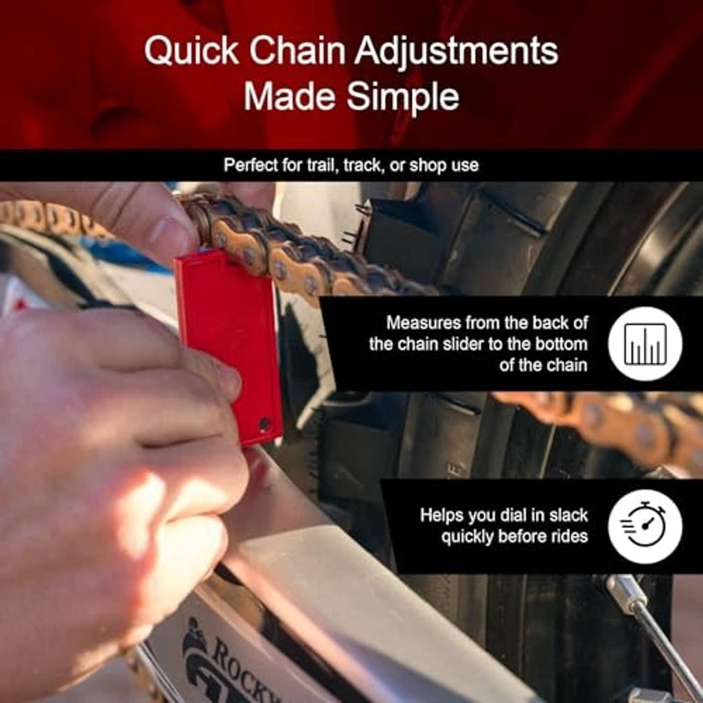 Red chain slack measuring tool held against a motorcycle chain by two hands