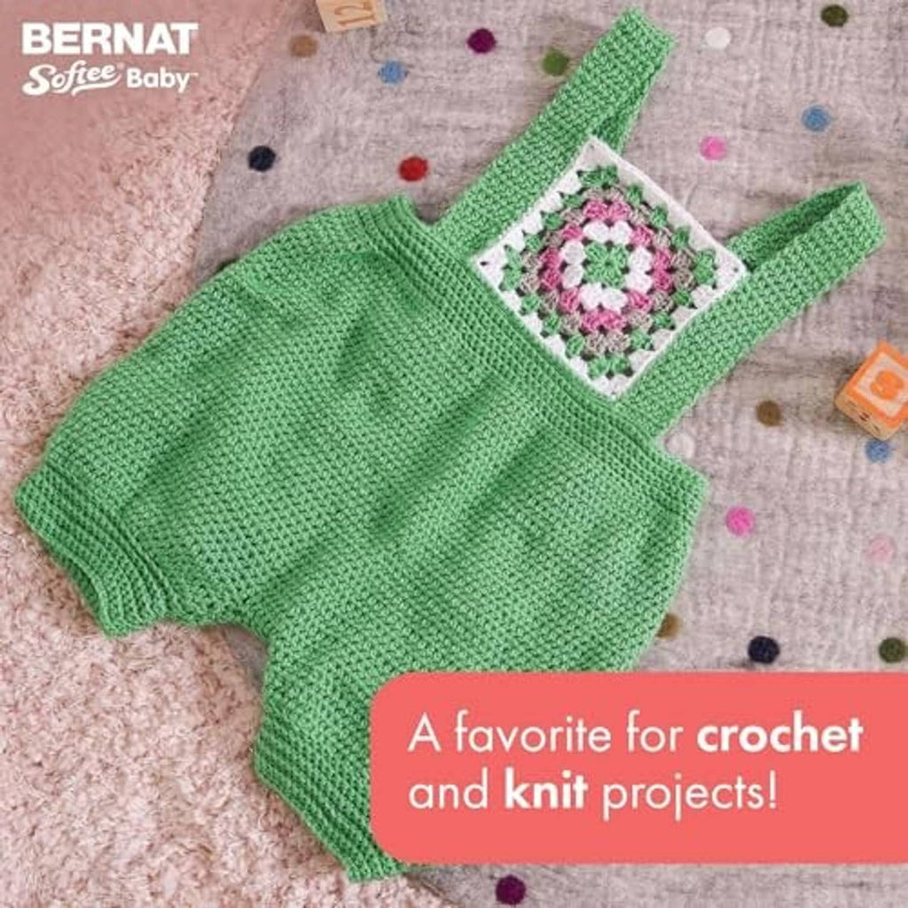 Green knitted baby sweater with small multicolor square detail