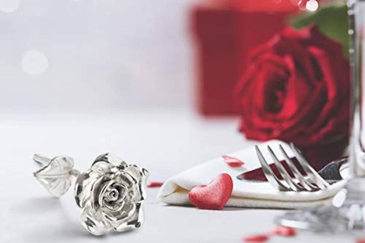 Silver tin rose ornament with leaves on a stem-like base